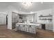 Stunning kitchen featuring a large island, bar stools, gray cabinets, and modern lighting at 11232 E Palomino Rd, Scottsdale, AZ 85259