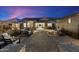 Outdoor seating area with patio furniture, umbrellas, brick paving, and manicured landscaping at dusk at 12365 E Gold Dust Ave, Scottsdale, AZ 85259