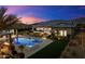 Inviting pool and spa area with lush landscaping, fire pit, and mountain views at twilight at 12365 E Gold Dust Ave, Scottsdale, AZ 85259