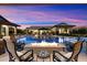 Luxurious pool and lounge area with built-in fire pit, multiple lounge seating areas and sunset views at 12365 E Gold Dust Ave, Scottsdale, AZ 85259