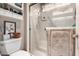 Bathroom featuring a glass-enclosed shower, white toilet, and built-in shelves for storage at 13602 W Ballad Dr, Sun City West, AZ 85375