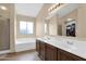 Bathroom featuring dual sinks, tile floors, a soaking tub, and a separate walk-in shower at 13641 W Solano Dr, Litchfield Park, AZ 85340