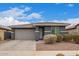 Charming home featuring a tile roof, gray exterior, brick driveway and beautiful landscaping at 14433 W Via Del Oro Dr, Surprise, AZ 85379