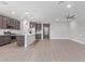 Open-concept living room showcasing wood-look tile flooring, a ceiling fan, and a kitchen view at 14433 W Via Del Oro Dr, Surprise, AZ 85379