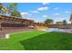 Expansive backyard with lush green grass and a shaded patio area, ideal for outdoor enjoyment at 15764 W Shiloh Ave, Goodyear, AZ 85338