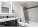 This bright bathroom features a modern sink, shower-tub combo, and dark wood cabinets at 15764 W Shiloh Ave, Goodyear, AZ 85338