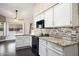 Well-lit kitchen featuring white cabinetry, granite countertops, and modern appliances at 15764 W Shiloh Ave, Goodyear, AZ 85338