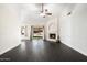 Spacious living room with fireplace, sliding glass doors to backyard, and modern ceiling fan at 15764 W Shiloh Ave, Goodyear, AZ 85338
