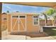 Backyard storage shed with double doors and decorative lattice detail at 15764 W Shiloh Ave, Goodyear, AZ 85338