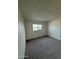 Clean bedroom with neutral carpet, white walls, and a bright window at 1853 W Burgess Ln, Phoenix, AZ 85041