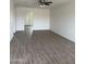 Bright living room features sleek wood floors, white painted brick wall, and a modern ceiling fan at 1853 W Burgess Ln, Phoenix, AZ 85041