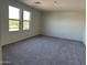 Bright bedroom with neutral carpet and two large windows at 1977 E Harness Ln, San Tan Valley, AZ 85140