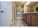 Well-lit bathroom featuring a glass-enclosed shower, double sinks, and tile floors at 20156 N 269Th Ln, Buckeye, AZ 85396