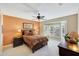 Primary bedroom with large bed, warm lighting, and plantation shutters at 20462 N Ridgewood Ln, Surprise, AZ 85374