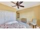 Neutral-toned bedroom with a ceiling fan, mirrored closet doors, and a charming decorative chair at 20462 N Ridgewood Ln, Surprise, AZ 85374