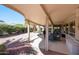 Inviting covered patio featuring ample seating and a meticulously landscaped backyard with decorative rock and lush plantings at 20462 N Ridgewood Ln, Surprise, AZ 85374
