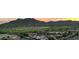 Expansive aerial view of luxury homes near a golf course against a mountain backdrop at sunset at 2067 N Marketside Ave, Buckeye, AZ 85396