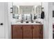 Bathroom vanity with double sinks, a large mirror, brown cabinets, and modern fixtures at 2067 N Marketside Ave, Buckeye, AZ 85396