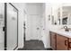 Hall bathroom with a glass shower, modern vanity, double sinks, and black tile floors at 2067 N Marketside Ave, Buckeye, AZ 85396