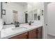 Bathroom featuring a double sink vanity, mirrors, and neutral decor at 2067 N Marketside Ave, Buckeye, AZ 85396