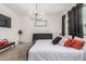 Bedroom featuring a black metal frame bed, stylish chandelier, and windows with dark curtains at 2067 N Marketside Ave, Buckeye, AZ 85396