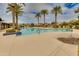 Resort-style community pool surrounded by palm trees, lounge chairs, and clear blue water at 22853 E Estrella Rd, Queen Creek, AZ 85142