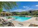 Community swimming pool surrounded by lounge chairs, landscaping, and multi-story apartment buildings at 2425 W Bronco Butte Trl # 2008, Phoenix, AZ 85085
