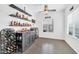 Stylish bar area with open shelving for liquor and wine storage, and a modern ceiling fan at 26065 W Yukon Dr, Buckeye, AZ 85396
