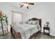 Cozy bedroom with a wood frame bed, ceiling fan, and neutral color palette at 26065 W Yukon Dr, Buckeye, AZ 85396