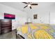 This bedroom features a ceiling fan, dresser, and a decorative mirror on the wall at 26065 W Yukon Dr, Buckeye, AZ 85396