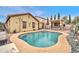 Sparkling pool surrounded by a stone patio and lush landscaping; an entertainer's dream at 26065 W Yukon Dr, Buckeye, AZ 85396