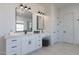 Bright bathroom with double vanity, sleek mirrors, and a view to the outside at 27776 N Gary Rd, Queen Creek, AZ 85144