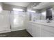 Bright bathroom featuring double sinks, a large mirror, and a glass-enclosed shower at 38197 W San Clemente St, Maricopa, AZ 85138