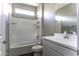 This bathroom features a shower-tub combo with white tile and white sink with modern faucet at 38197 W San Clemente St, Maricopa, AZ 85138