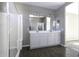 Modern bathroom showcasing double sinks, a wide mirror, and a glass shower at 38197 W San Clemente St, Maricopa, AZ 85138