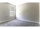 This cozy bedroom has neutral walls, gray carpet and a window with a view of the neighborhood at 38197 W San Clemente St, Maricopa, AZ 85138