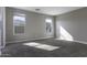 Bedroom with two windows allowing ample natural light and plush carpeting throughout at 38197 W San Clemente St, Maricopa, AZ 85138
