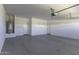 Spacious two car garage with freshly painted concrete floors, water heater, and two access doors at 38197 W San Clemente St, Maricopa, AZ 85138