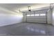 An empty spacious two car garage with an automatic door and painted concrete floors, ready for use at 38197 W San Clemente St, Maricopa, AZ 85138