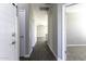 Hallway features neutral colored walls and a dark wood-look tile, with bedroom doors and a view to the living area at 38197 W San Clemente St, Maricopa, AZ 85138