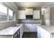 View of a kitchen with white cabinets, stainless steel microwave and sink, and granite countertops at 38197 W San Clemente St, Maricopa, AZ 85138