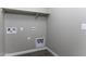 Functional laundry room with hookups and overhead shelving at 38197 W San Clemente St, Maricopa, AZ 85138