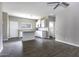 Open-concept living space featuring a modern kitchen, dining area, and wood-look flooring at 38197 W San Clemente St, Maricopa, AZ 85138