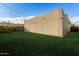 View of the backyard with green grass and a light colored house against a blue sky at 407 E Eason Ave, Buckeye, AZ 85326