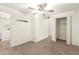 A bright room features a ceiling fan and closet doors, as well as a laundry room at 407 E Eason Ave, Buckeye, AZ 85326