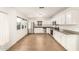 Bright kitchen featuring white cabinetry, stainless steel appliances, and wood-look floors at 407 E Eason Ave, Buckeye, AZ 85326
