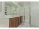 A bathroom featuring a dual sink vanity, white countertop, and framed shower with clear glass doors at 4429 W Paseo Way, Laveen, AZ 85339
