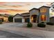 Charming two-story home with a three-car garage and beautifully landscaped front yard against a colorful sunset sky at 4429 W Paseo Way, Laveen, AZ 85339