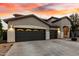 View of the home's three-car garage with large driveway and well maintained landscaping at 4429 W Paseo Way, Laveen, AZ 85339