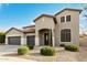 A two story home with a three car garage, desert landscaping, and a covered front entryway at 4429 W Paseo Way, Laveen, AZ 85339